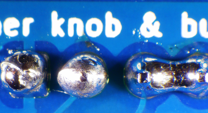 Photo of a board with four incorrectly soldered joints. Two are bridged with solder, and two have an excess amount of solder.